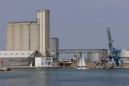 France, Hérault (34), Sète, voilier devant un silo à grains dans le port industriel et commercial