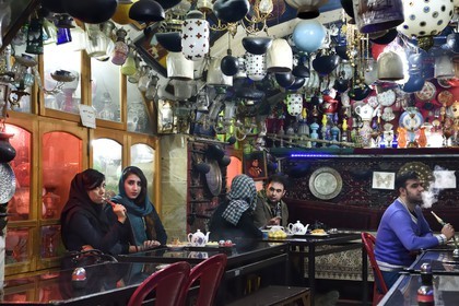 Iran, province d'Ispahan, Ispahan, la maison de thé et restaurant Chai Khaneh Azadegan, homme et femme fumant la pipe à eau