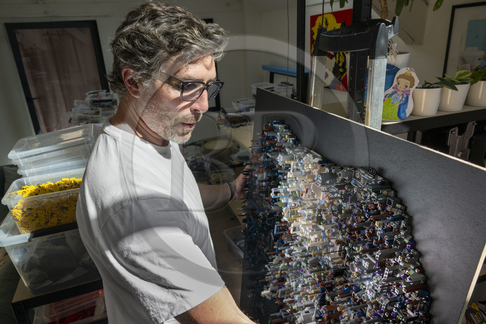 France, Côte-d'Or (21), Dijon, l'artiste Aymeric Gillet alias M'Brick dans son atelier rempli de caisses de Légo multicolores utilisés pour créer des tableaux géants pixellisés inspirés par la pop culture