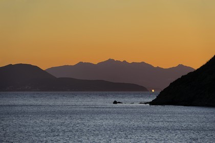 Italie, Toscane, l’Ile d’Elbe au coucher de soleil et la côte à Piombino en premier plan