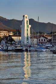 France, Pyrenees Atlantiques, Basque Country, Saint Jean de Luz, boat at the port and lighthouse of Ciboure built by André Pavlovsky in 1936, the summit of Larrun (La Rhune) mountain in the background