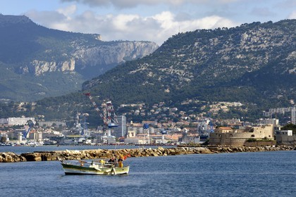France, Var, Toulon harbour, fishing boat in front of the big dike, the Charles de Gaulle nuclear-powered aircraft carrier and the Royal Tower (1514) in the background