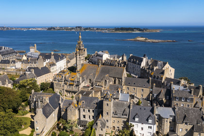 France, Finistère, Roscoff, the bell tower of the Notre-Dame de Croaz Batz church and the back of old shipowners' houses including those of the James brothers built at the end of the 16th century, the Batz island in the background (aerial view)