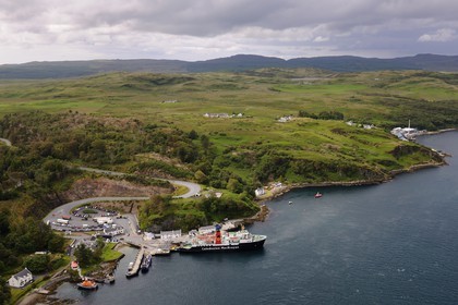 Royaume-Uni, Ecosse, Hébrides intérieures, Ile de Islay, ferry à quai à Port Askaig, distillerie de whisky Caol Ila en arrière plan (vue aérienne)