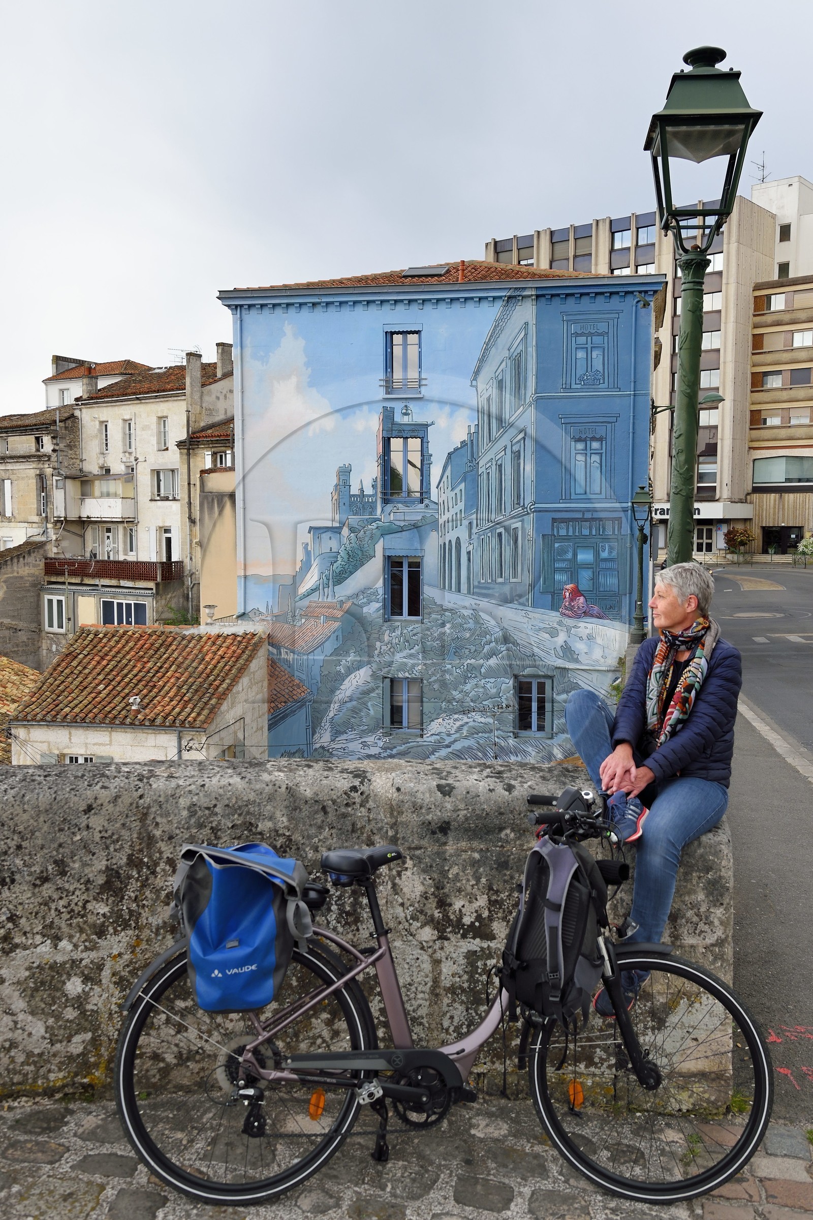 France, Charente (16), Angoulême, Boulevard Pasteur dans le centre historique, cycliste faisant la véloroute La Flow Vélo devant La fille des Remparts, mur peint d'après un dessin original de Max Cabanes et réalisé par la Cité de la création en 2004