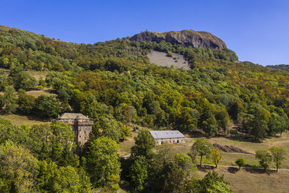 France, Cantal, Parc Naturel Régional des Volcans d'Auvergne (regional nature park of Auvergne volcanoes), Brezons, the Brezons valley, 15th century Keep of Boyle castle and the gigantic lava plug of La Boyle rock in the background (aerial view)