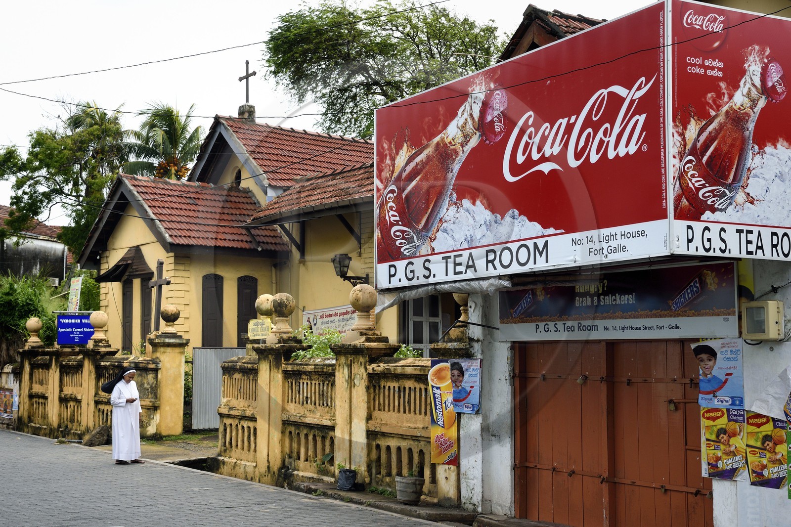 Sri Lanka, Province du Sud, Fort de Galle, classé Patrimoine Mondial de l'UNESCO, nonne devant le Apostolic Carmel Sisters dans lighthouse street et panneau publicitaire pour Coca-Cola