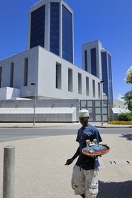 Tanzanie, Dar es-Salaam, petit vendeur devant les twin towers de la Bank of Tanzania