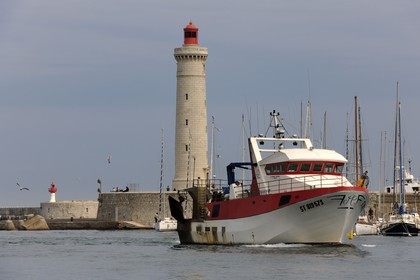 France, Hérault (34), Sète, Vieux Port, retour de pêche d'un chalutier et le phare du Môle Saint-Louis
