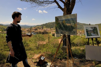 France, Aude, Lagrasse village, labelled Les Plus Beaux Villages de France (The Most Beautiful Villages of France), a painter in front of the village