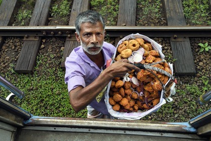 Sri Lanka, Province du Centre, trajet en train dans la région montagneuse de la culture du thé entre Hatton et Ella, gare de Talawakele, vendeur ambulant de beignets de crevettes et de wade