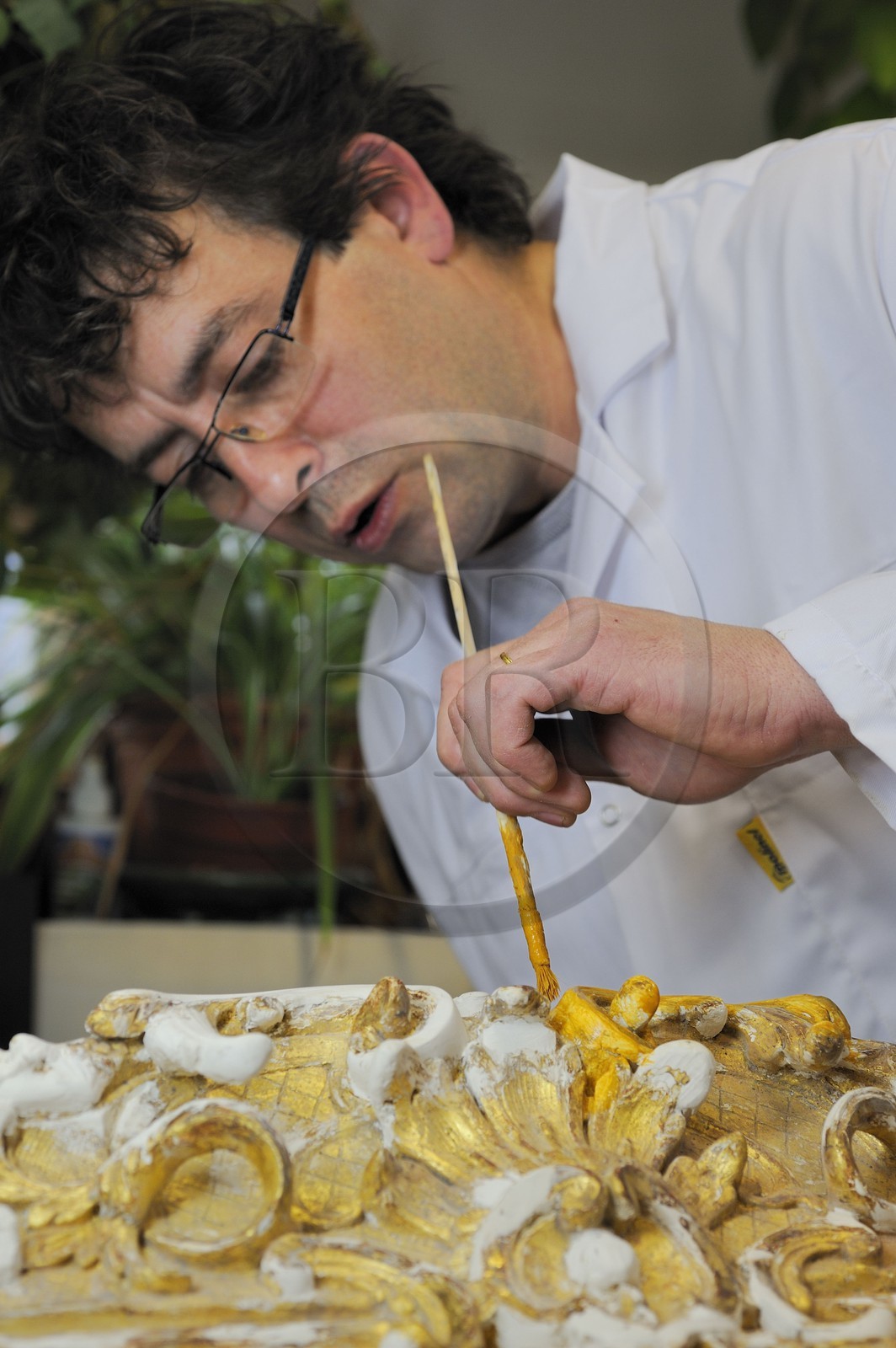 France, Yvelines (78), château de Versailles, ateliers de restauration du château, atelier de dorures, Laurent Hissier travaillant sur un cadre de tableau