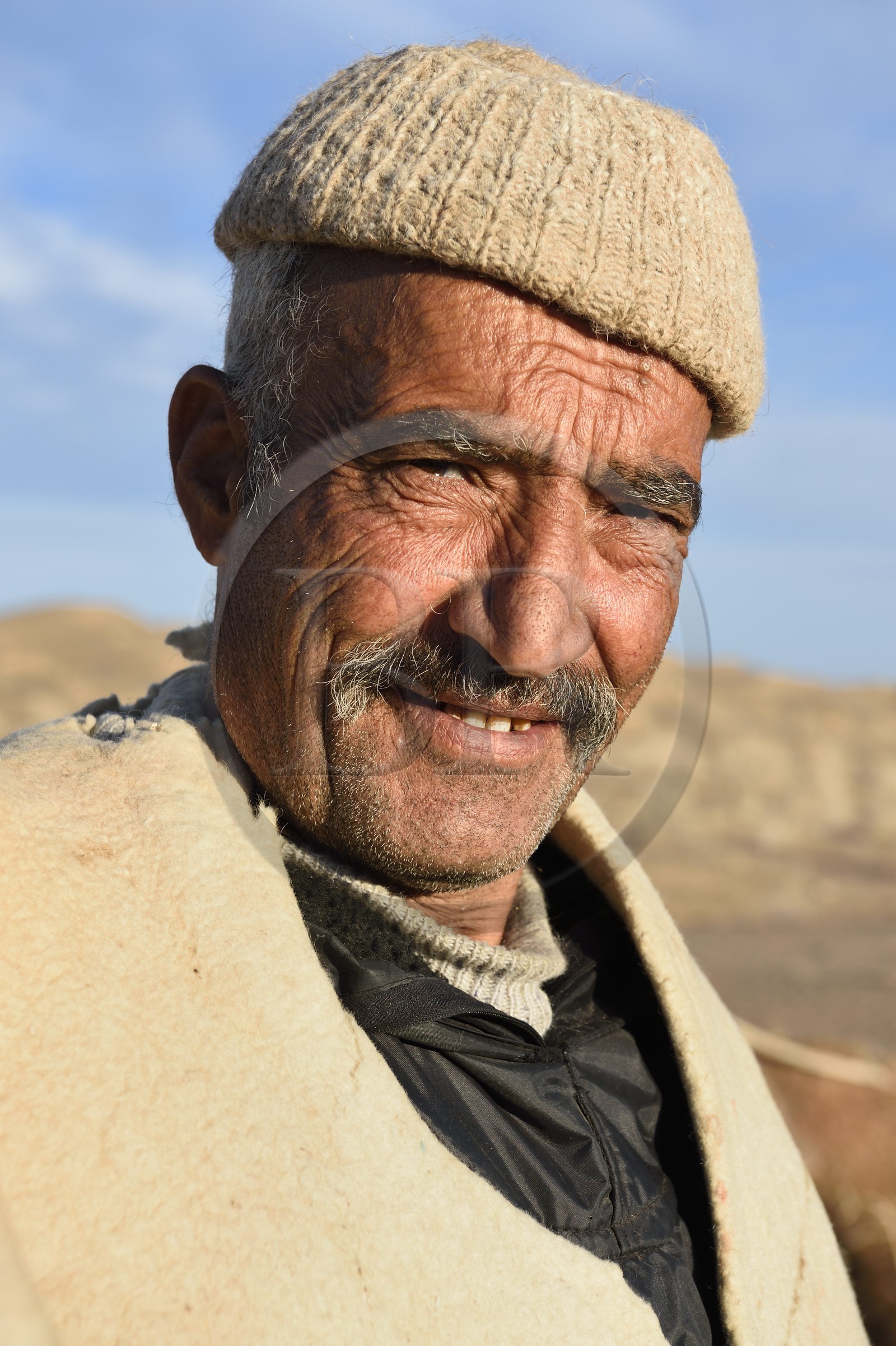 Iran, Province d'Ispahan, désert du Dasht-e Kavir, Mesr dans la région de Khur et Biabanak, le chamelier Ali Saraban portant le feutre en laine de chameau (namad) de son grand-père