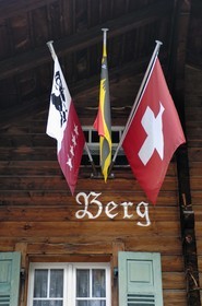 Switzerland, Canton of Bern, Bernese Oberland, Murren village, traditional chalet with Bernese Oberland and Switzerland flags