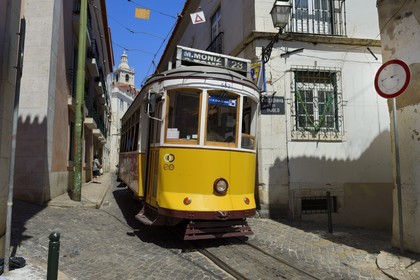 Portugal, Lisbon, Alfama district, tram (electricos) along Rua das Escolas Gerais with the tower of Sao Vicente de Fora church