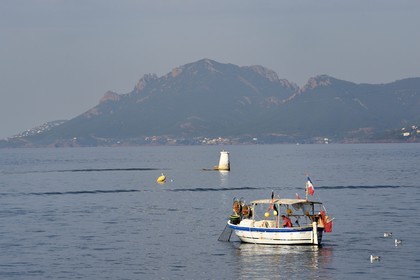 France, Alpes-Maritimes (06), Cannes, Iles de Lérins, bateau de peche au large de l'Ile Sainte-Marguerite et le massif des Maures en arrière plan