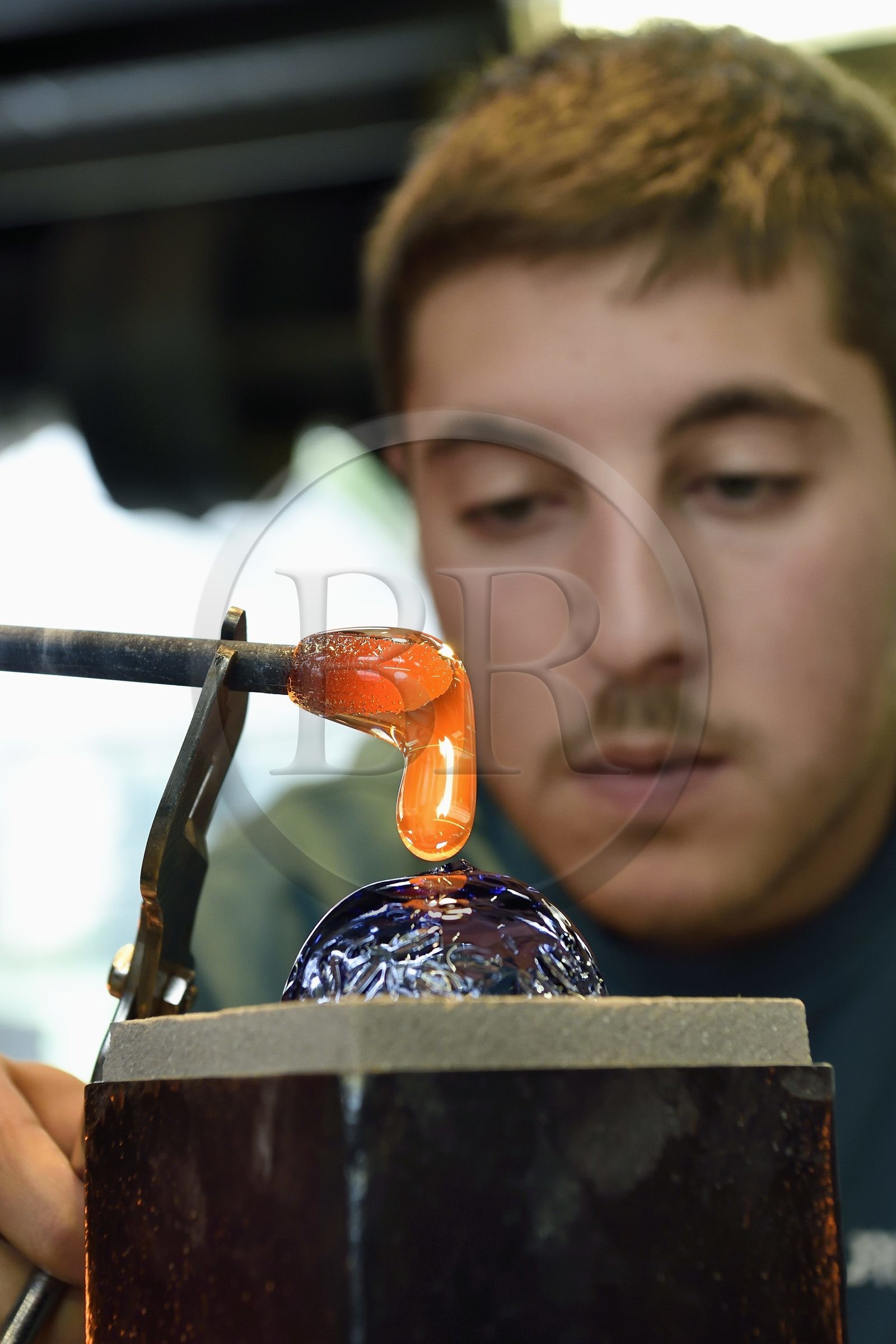 France, Moselle (57), Meisenthal, Centre international d’Art verrier (CIAV), l'atelier de soufflage, fabrication artisanale d'une boule de Noël, pose de la pastille pour la création du crochet en verre