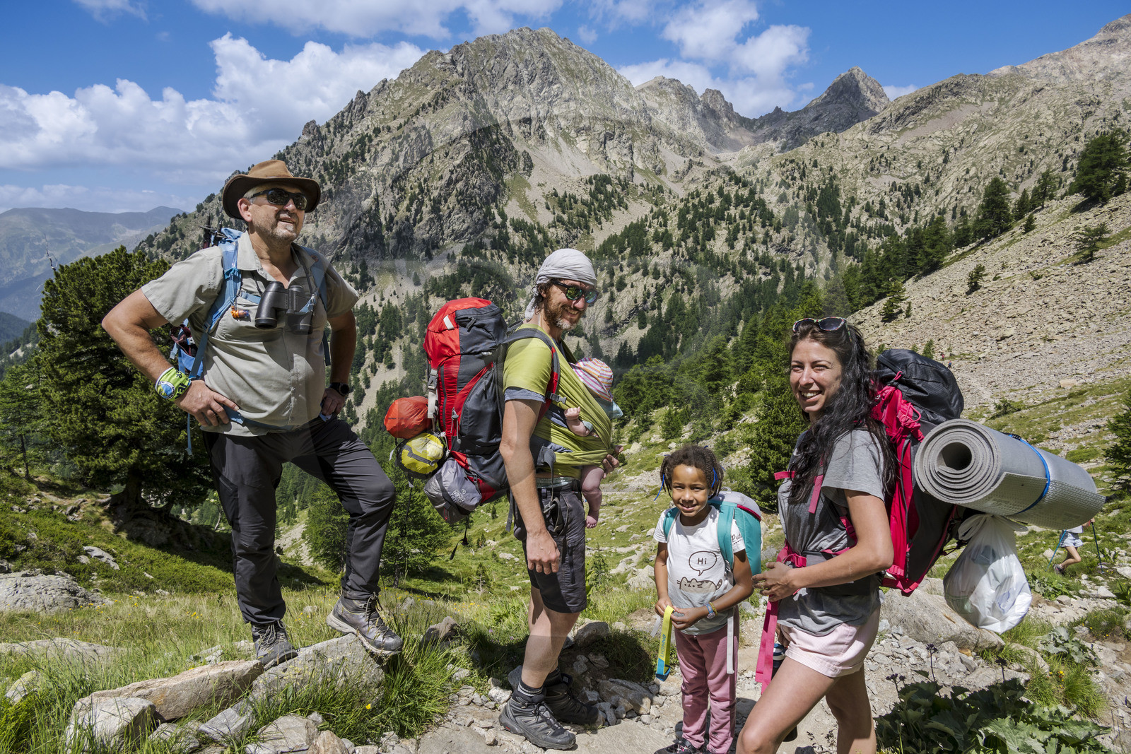 France, Alpes-Maritimes (06), parc national du Mercantour, Haute-Vésubie, Saint-Martin-Vésubie, Val du Haut Boréon, le guide Nicolas Matteudi à gauche et une famille de randonneurs en marche pour le refuge de Cougourde à droite