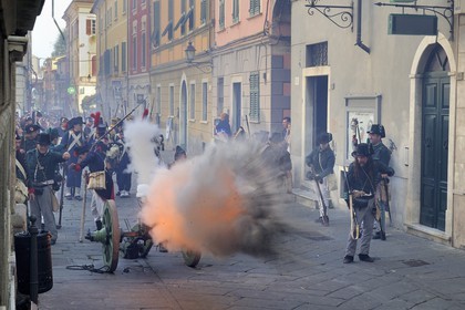 Italy, Liguria, Sarzana, Piazza Matteotti, Napoleon Festival, french soldiers of the Grande Armée firing the cannon on the austrian enemy in the main street Via Mazzini in the old town
