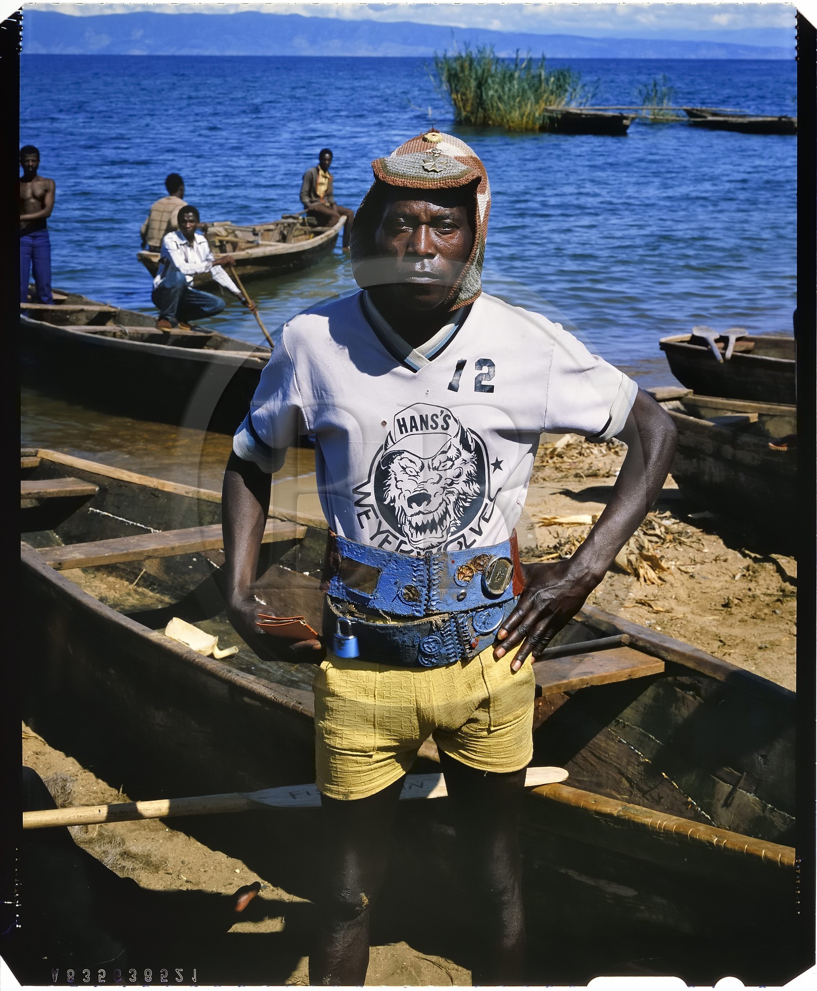 Burundi, province de Rumonge, groupe de pêcheurs au bord du lac Tanganyika, personnage haut en couleur, ce pêcheur Hutu surnommé le fou parvenait par près de 40°c à garder son bonnet en laine sur lequel il a accroché une croix de guerre allemande et une capsule de bière Primus, en arrière plan on apercoit la pointe de Burton et Speke située au Congo (reproduction plan-film inversible 4x5)