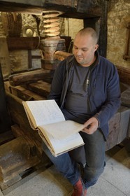 France, Bas Rhin, the Alsace Wine Route, Mittelbergheim, labelled Les Plus Beaux Villages de France (The Most Beautiful Villages of France), the wine-conservatory museum, the winemaker Nicolas Wittmann consulting the historical book of the village harvest