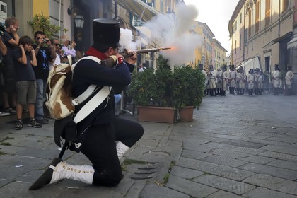 Italy, Liguria, Sarzana, Napoleon Festival, french soldier of the Grande Armée firing at the austrian enemy in the main street Via Mazzini in the old town