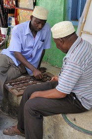 Tanzania, Zanzibar Archipelago, Unguja island (Zanzibar), Stone Town, listed as World Heritage by UNESCO, two men playing Awale the traditional game of Africa in the old city in the Shangani neighborhood