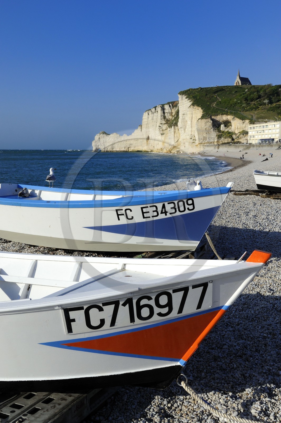 France, Seine-Maritime, Pays de Caux, Cote d'Albatre, Etretat, Amont cliff and Notre-Dame-de-la-Garde church seen from the beach of the town with fishermen's boats