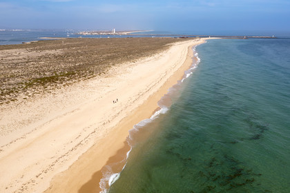 Portugal, Algarve, Ria Formosa Natural Park, Faro, Island of Barreta or Deserta (Ilha da Barretta or Deserta), the lighthouse of Ilha do Farol part of  Ilha da Culatra in the background (aerial view)