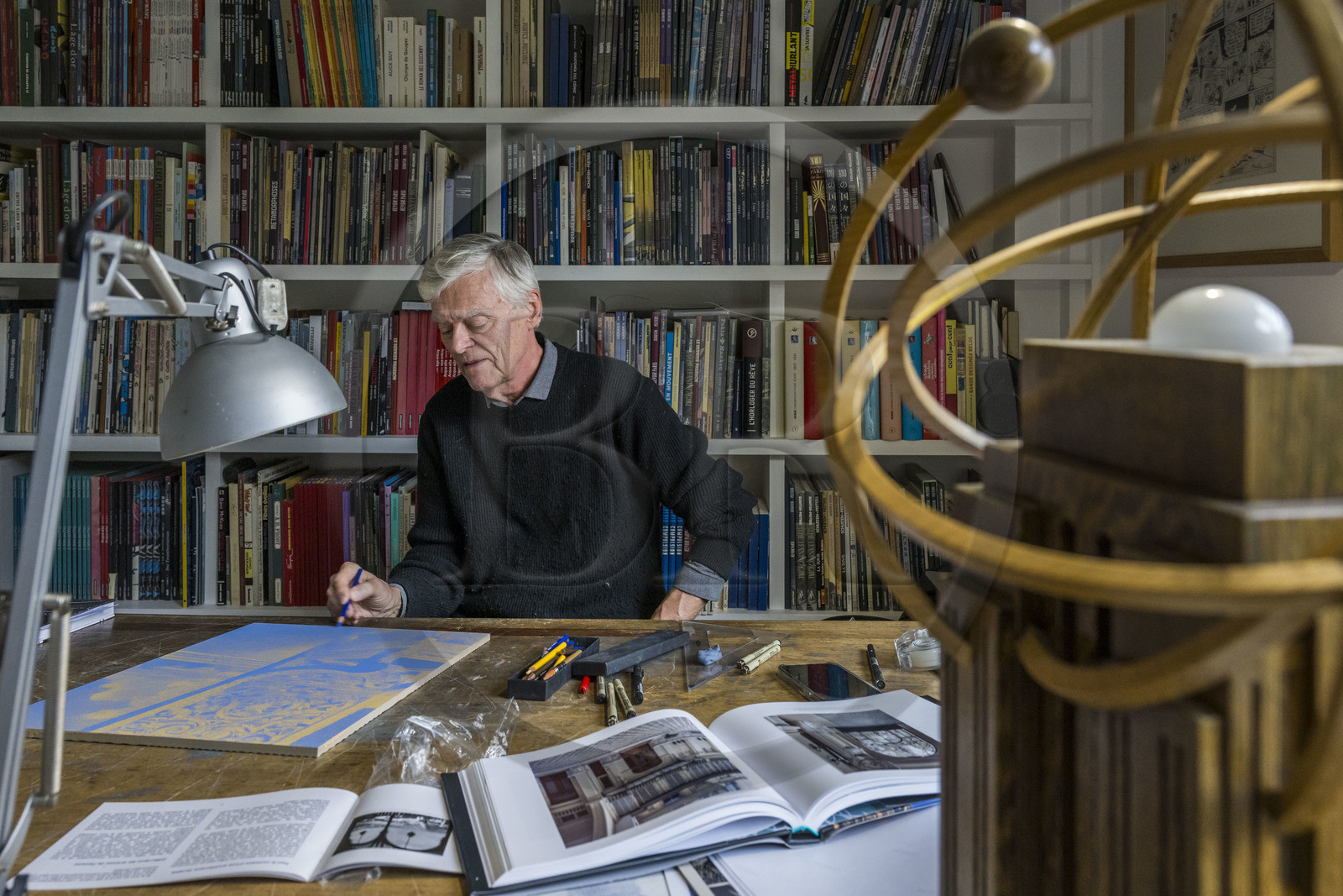 France, Paris (75), le dessinateur et auteur de bande-dessinée François Schuiten dans son atelier parisien, il fait des retouches à son dessin sur une des futures plaques de céramique qui orneront le quai de la station de métro Pont de Sèvres du futur réseau du Grand Paris Express