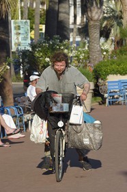 France, Alpes-Maritimes, Cannes, the Croisette, tramp on bicycle