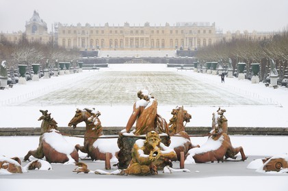 France, Yvelines, snow covered park of the Chateau de Versailles, listed as World Heritage by UNESCO, Apollo Basin by Tuby with the Apollo's Cart and Axe du Soleil (the Sun Axis) to the castle