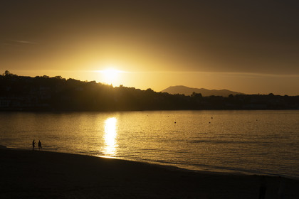 France, Pyrenees Atlantiques, Basque Country, Saint Jean de Luz, walkers on the Grande Plage and the coast of Ciboure in the bay in the background