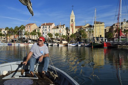 France, Var, Sanary-sur-Mer, traditional fishing boats called pointus in the port and St. Nazaire Church, Christian Benet who is president of the Sanary Pointus association