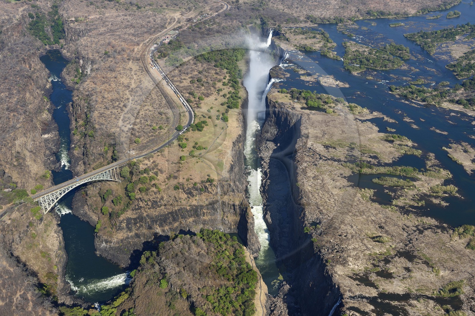 Zimbabwe, province de Matabeleland septentrional, fleuve Zambèze, les Chutes Victoria, classées Patrimoine Mondial de l'UNESCO, pont qui marque la frontière entre le Zimbabwe et la Zambie (vue aérienne)