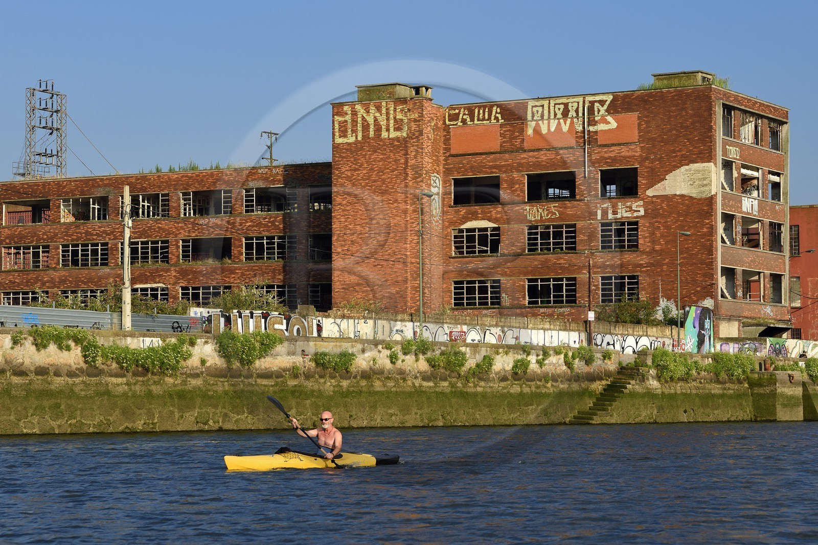 Espagne, Pays basque espagnol, Biscaye, Bilbao, kayakiste remontant le fleuve Nervion vers l'embouchure, friche industrielle de Deusto, ancien batiment industriel Espagne, Pays basque espagnol, Biscaye, Bilbao, kayakiste remontant le fleuve Nervion vers l'embouchure, friche industrielle de Deusto, ancien batiment industriel