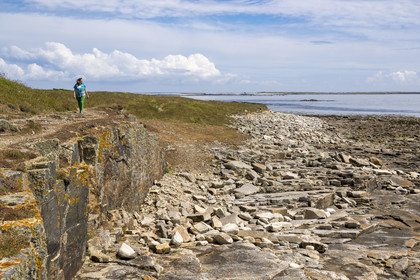 France, Finistère, Iroise Sea, Molene Island, Christine Demeure who manages the only grocery store on the island during her daily walk on the wild west coast, Flat Stones shore