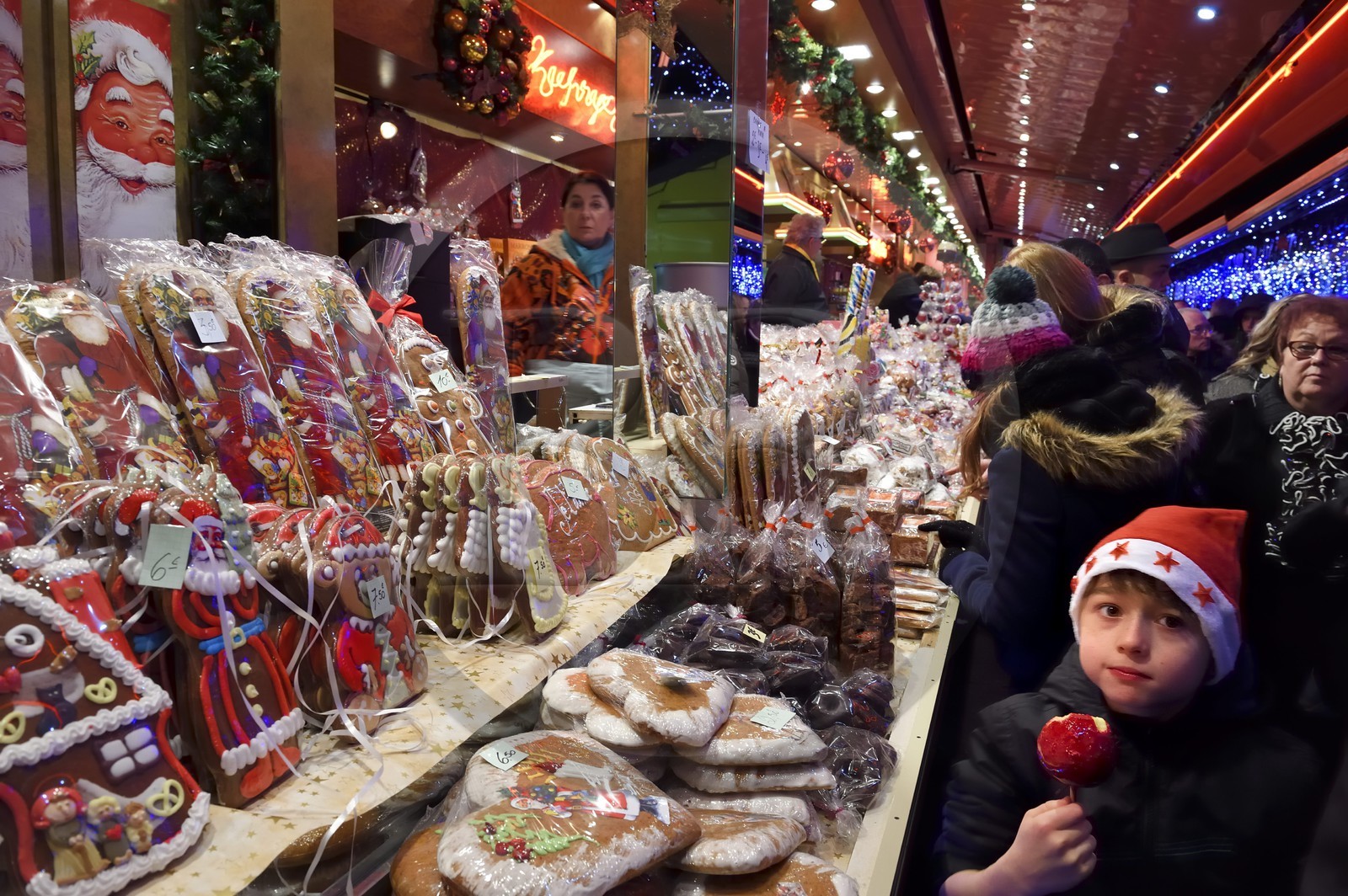 France, Bas-Rhin (67), Strasbourg, vieille ville classée Patrimoine Mondial de l'UNESCO, marché de Noël (Christkindelsmarik) de la place Broglie, enfant mangeant une Pomme d'Amour