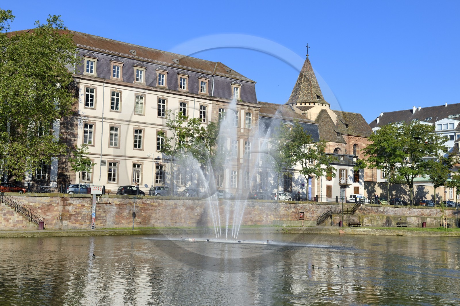 France, Bas-Rhin (67), Strasbourg, vieille ville classée au Patrimoine Mondial de l'UNESCO, jet d'eau sur la rivière ill et le collège épiscopal Saint-Etienne en arrière plan
