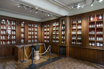 France, Cote d'Or, Beaune, area listed as World Heritage by UNESCO, Hospices de Beaune, Hotel Dieu, glass bottles and collection of earthenware jars with green decorations from the 18th century in the pharmacy or apothecary