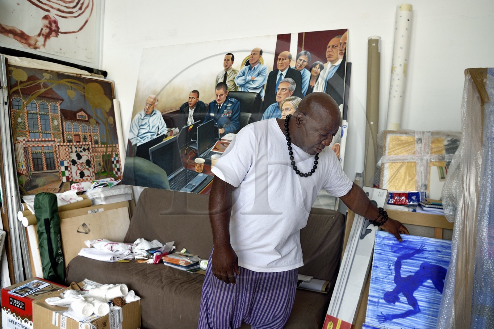 France, Paris, Barthelemy Toguo, the artist founder of Bandjoun Station in Cameroon (shown in the painting in the background), in his Parisian studio