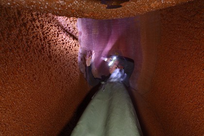 France, Bas Rhin, the Alsace Wine Route, Mittelbergheim, labelled Les Plus Beaux Villages de France (The Most Beautiful Villages of France), Domaine Wittmann wine cellar, inside of a large wine barrel cleaning