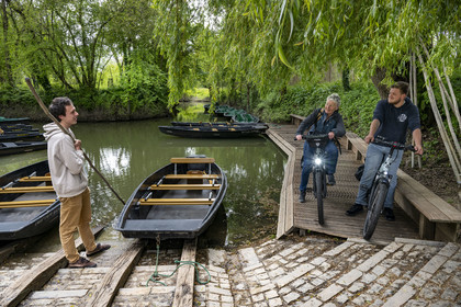 France, Vendée (85), Maillezais, cycliste en discussion avec un batelier tenant sa pigouille (perche en bois) au Grand Port, embarcadère de l'Abbaye