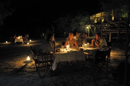 Tanzanie, Reserve de gibier de Selous une des plus grandes zones protégées au monde et inscrite sur la liste du patrimoine mondial de l’Unesco depuis 1982, le très exclusif Selous Camp, diner en extérieur de nuit