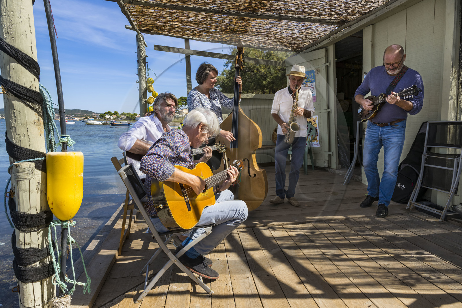 France, Hérault (34), Sète,  Pointe du Barrou sur les rives de l'étang de Thau, le groupe de musique Au Bois de mon cœur qui réinterprète les chansons de Georges Brassens, il est mené par le pêcheur sétois Jean-Louis Lambert au chant et à la guitare, Georges Cabaret à la guitare solo, Guy Blanc dit Guet au saxo alto, Denis Benito à la mandoline bluegrass et Tatiana à la contrebasse