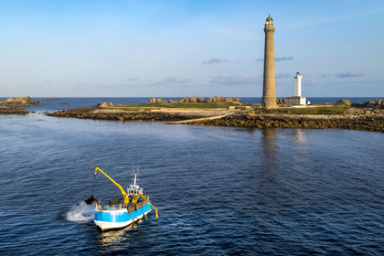 France, Finistère (29), Pays des Abers, Ile Vierge dans l'archipel de Lilia, bateau goémonier utilisant un de ses deux bras mécaniques articulés se terminant par un scoubidou pour récolter des algues marines le goémon, le phare de l'Ile Vierge en arrière plan (vue aérienne)