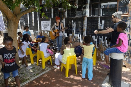 South Africa, Gauteng Province, Johannesburg, CBD (Central Business District), Maboneng district, Sidewalk Sessions in Fox street, Kelly Grevler gives free guitar lessons for young children in the street