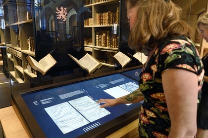 France, Bas Rhin, Selestat, the Humanist Library refitted by architect Rudy Ricciotti, digital reading of the liturgical Lectionary book called Merovingian Lectionary, manuscript on parchment in Latin (7th century), the personal library of Beatus Rhenanus (1485-1547) is in the background in the glass room