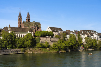 Switzerland, Basel, the left bank of the Rhine, the Minster or Protestant Cathedral of Our Lady of Basel (Munster) overlooking the Rhine and one of the four small ferries that connect the banks of the Rhine