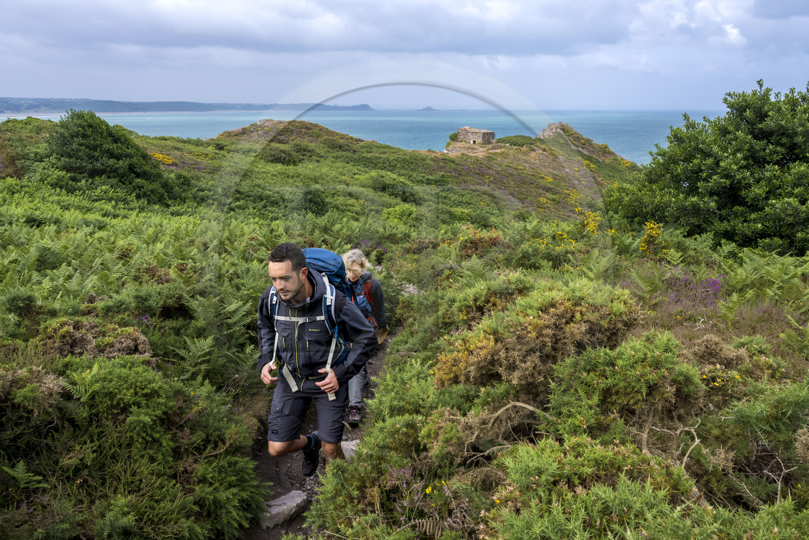 France, Côtes d'Armor (22), Grand Site de France Cap d'Erquy – Cap Fréhel, Erquy, randonneurs sur le chemin de Grande Randonnée GR34 avec en arrière plan le Four à boulet